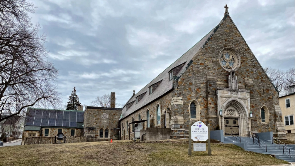 A stone church building in front of a gray sky